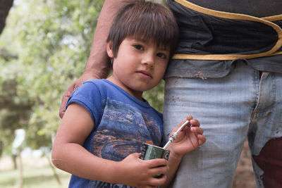 Portrait of boy with father standing outdoors