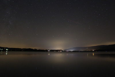 Scenic view of lake against sky at night