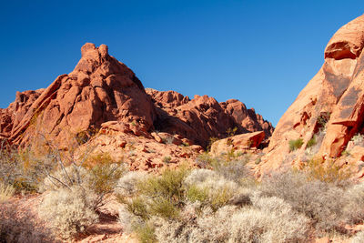 Rock formations on landscape against blue sky