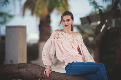 Portrait of young woman sitting outdoors