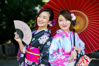 Portrait of a smiling young woman holding umbrella