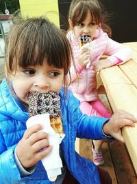 Girl with sister eating waffle at table