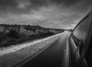 Road by mountain against sky