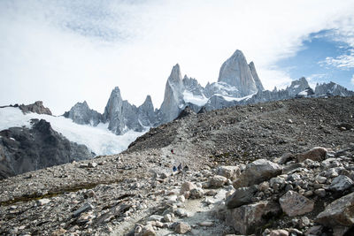 Scenic view of rocky snowcapped mountains against cloudy sky