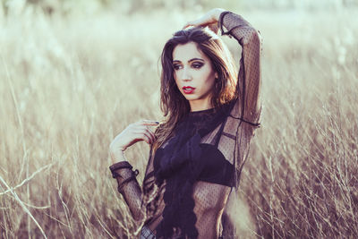 Thoughtful young woman standing on field