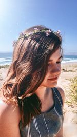 Close-up of young woman at beach against sky