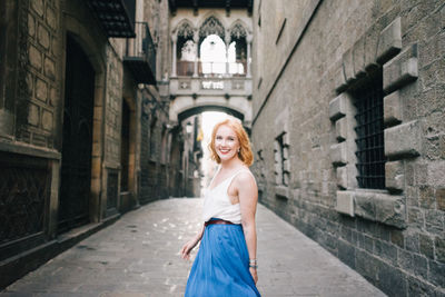 Portrait of young woman in front of building