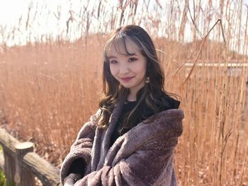 Portrait of young woman standing amidst plants