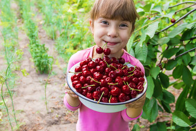 Portrait of cute girl holding fruit