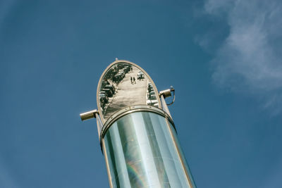 Low angle view of mirror against blue sky