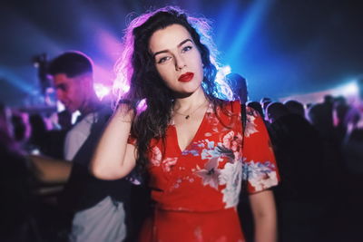 Portrait of young woman at concert during night