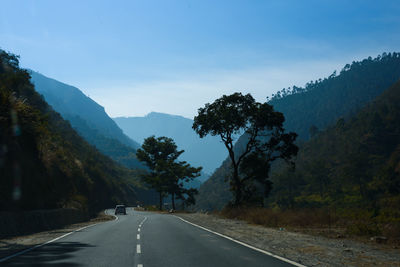 Road amidst trees against sky