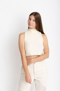 Portrait of young woman standing against white background