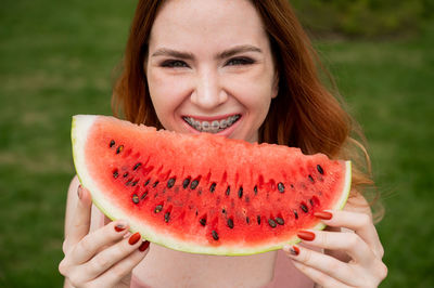 Close-up of young woman holding orange