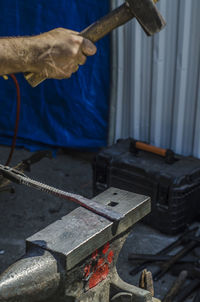 Cropped hand of worker holding hammer in workshop