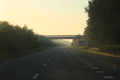 Empty road against sky during sunset