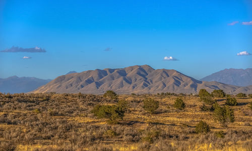 Scenic view of mountain range against blue sky