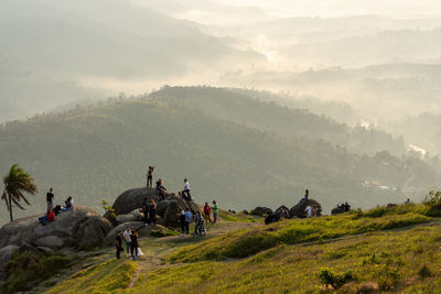 Group of people on field against mountain range