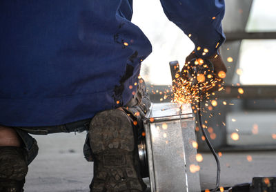 Low section of man cutting metal