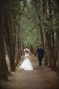 Rear view of couple walking in forest