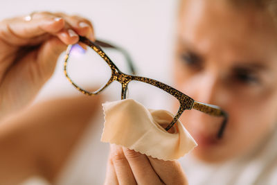 Woman with ocd or obsessive compulsive disorder. cleaning her eyeglasses.