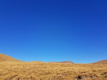 Scenic view of desert against clear blue sky