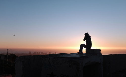 Silhouette man against sky during sunset