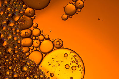 Yellow and orange bubbles, drops of oil in water. macro shot 