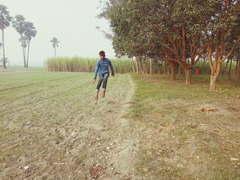 Rear view of man running on field