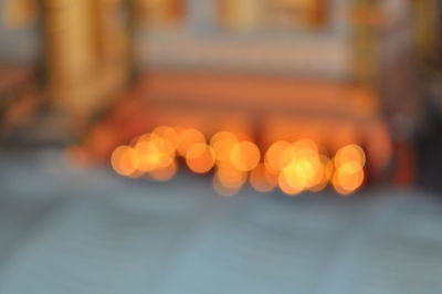 Defocused image of illuminated lights on street at night