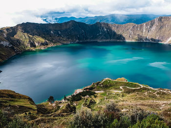 Scenic view of sea and mountains against sky