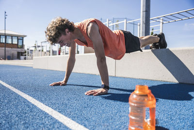 Happy sportsman doing push-ups on running track