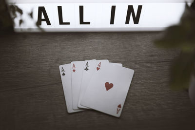 Close-up of cards by illuminated text on table