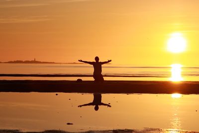 Silhouette of people on beach at sunset