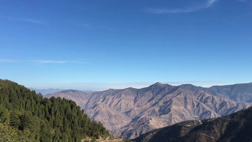 Scenic view of mountains against blue sky