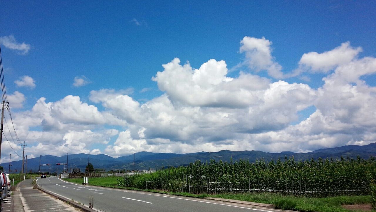 transportation, sky, road, the way forward, mountain, cloud - sky, landscape, cloud, country road, diminishing perspective, blue, vanishing point, nature, mountain range, tranquil scene, car, cloudy, scenics, tranquility, land vehicle