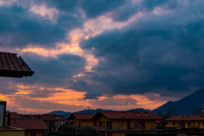 Houses and buildings against sky during sunset