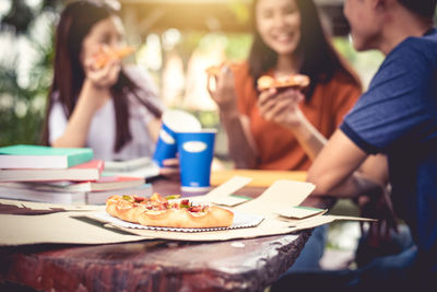 Friends having pizza at table