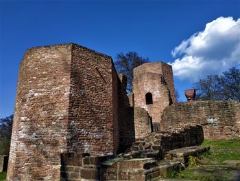 Low angle view of old ruin building against blue sky