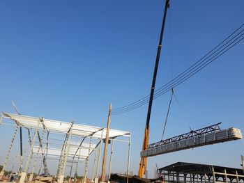 Low angle view of cranes against sky