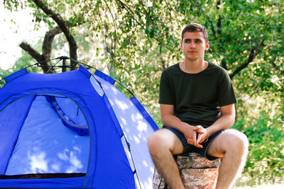 Man tent summer. defocus young man tourist sitting in touristic tent at the beach. camping