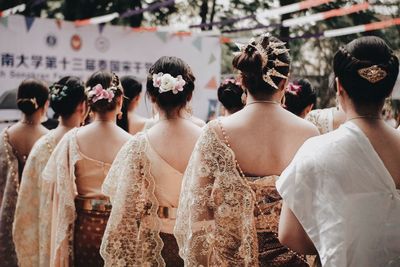 Rear view of women in traditional clothing standing outdoors