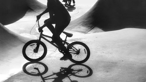 Low section of man riding bicycle on street