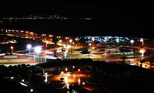 Illuminated city against sky at night