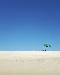 Scenic view of beach against clear blue sky