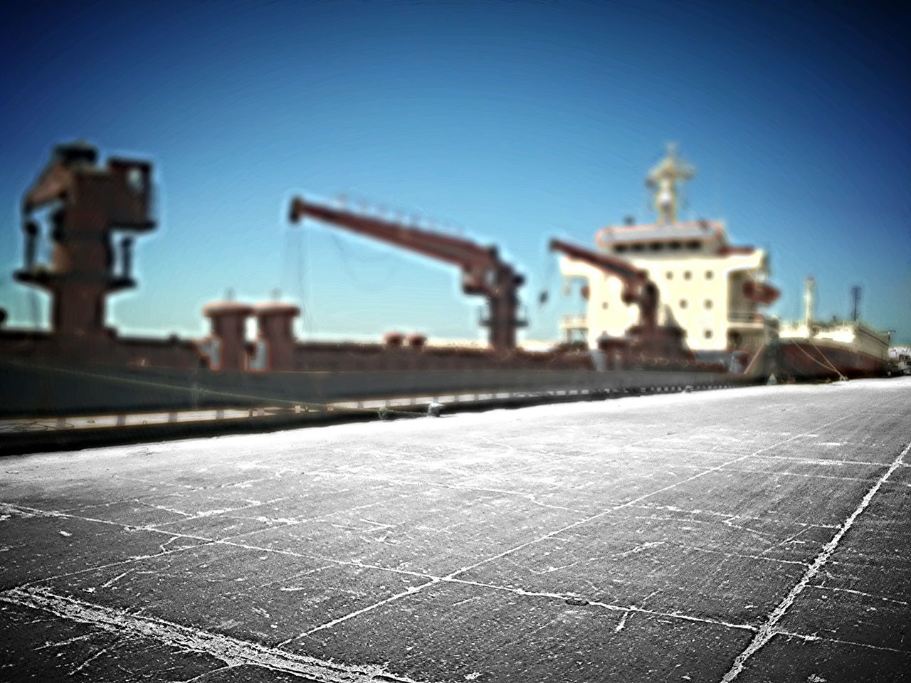 building exterior, architecture, built structure, clear sky, blue, copy space, outdoors, sky, surface level, city, sunlight, day, street, religion, no people, roof, selective focus, focus on foreground, road, the way forward