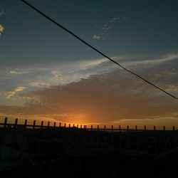 Silhouette of cables against sky during sunset