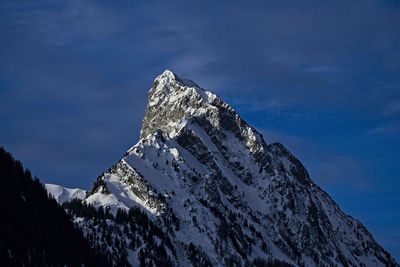 Low angle view of snowcapped mountain against sky