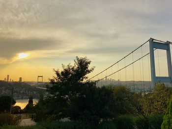 View of suspension bridge against cloudy sky