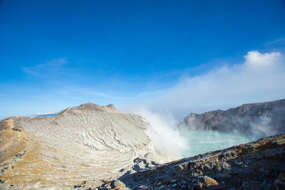 Scenic view of hot spring against sky